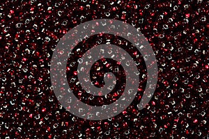 Shiny dark red glass seed beads background.