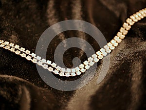 Shiny diamond necklace on black satin background for valentines day.