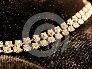 Shiny diamond necklace on black satin background for valentines day.