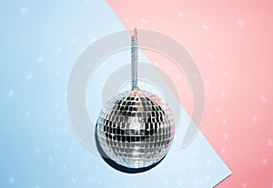 Shiny disco ball on a bright pastel creative background. Pop disco music style attributes eighties