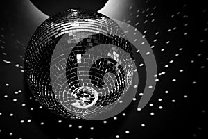 A shiny disco ball hangs on a black background in a nightclub