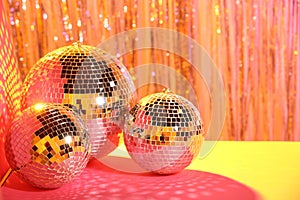 Shiny disco balls on blurred background, color toned. Space for text