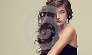 Shiny, freely laying curls of well groomed hair. Beauty portrait of young, perfektly looking woman.