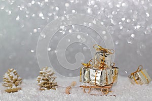 Shiny giftboxes on sledge, snow background with bokeh