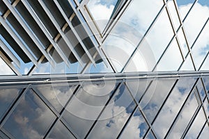 Shiny glass wall with darkening glass and sheer glass joint with sky reflection, mirrorlike