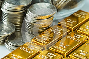 shiny gold bars with stack of coins as business or financial investment and wealth concept