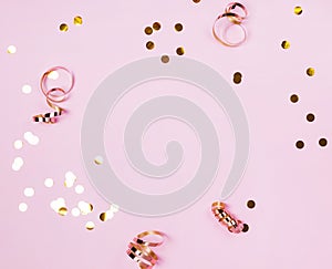 Shiny golden confeti and ribbons on pink background. photo