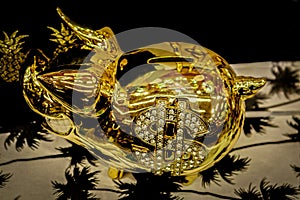Shiny golden piggy bank with reflections and rhinestone dollar sign viewed from above