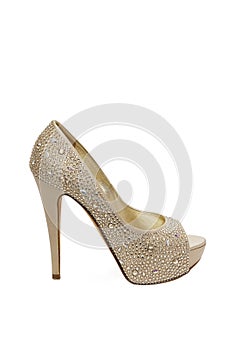 Shiny golden shoes with high-heeled stones isolated on white background