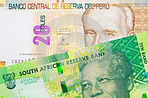 A shiny, green 10 rand bill from South Africa paired with a beige, twenty sol bill from Peru.