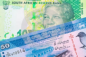 A shiny, green 10 rand bill from South Africa paired with a blue and white fifty rupee bank note from Sri Lanka.