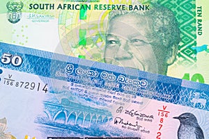 A shiny, green 10 rand bill from South Africa paired with a blue and white fifty rupee bank note from Sri Lanka.