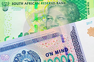 A shiny, green 10 rand bill from South Africa paired with a blue, white and green ten thousand som note from Uzbekistan.