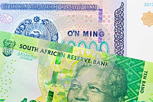 A shiny, green 10 rand bill from South Africa paired with a blue, white and green ten thousand som note from Uzbekistan.