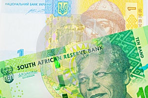 A shiny, green 10 rand bill from South Africa paired with a blue, white and yellow one hyrvnia bank note from Ukraine.