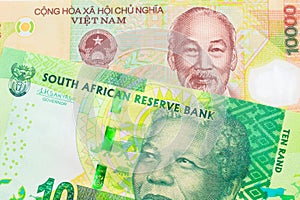 A shiny, green 10 rand bill from South Africa paired with a colorful, plastic ten thousand dong note from Vietnam.