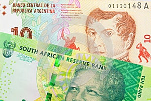 A shiny, green 10 rand bill from South Africa paired with a colorful ten peso note from Argentina.