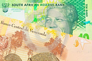 A shiny, green 10 rand bill from South Africa paired with a colorful, yellow five Bolivar bank note from Venezuela.