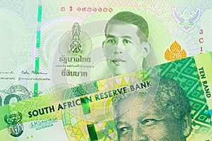 A shiny, green 10 rand bill from South Africa paired with a green twenty baht bank note from Thailand.