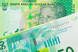 A shiny, green 10 rand bill from South Africa paired with a green and white fifty shekel bank note from Israel.