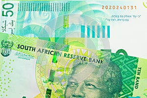 A shiny, green 10 rand bill from South Africa paired with a green and white fifty shekel bank note from Israel.