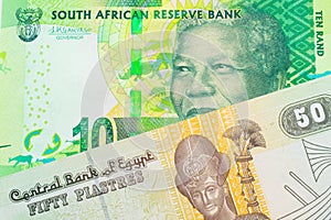 A shiny, green 10 rand bill from South Africa paired with a green and yellow fifty piastre note from Egypt.