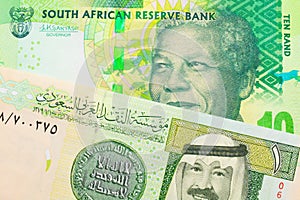 A shiny, green 10 rand bill from South Africa paired with a green and yellow on riyal bank note from Saudi Arabia.