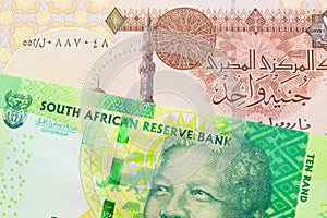 A shiny, green 10 rand bill from South Africa paired with a one pound banknote from Egypt.