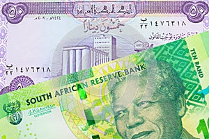 A shiny, green 10 rand bill from South Africa paired with a purple fifty dinar bill from Iraq.