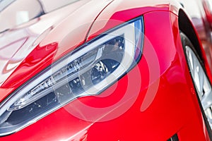 Shiny headlights on a red sports car