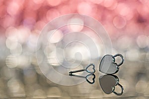 Shiny metal heart lock and key in red light and bokeh background