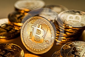 Shiny physical bitcoins on golden background. Blockchain technology