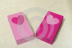 Shiny red and pink boxes decorated with hearts on silver background