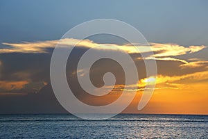shiny sea over cloudy sky and sun during sunset in Cozumel, Mexico