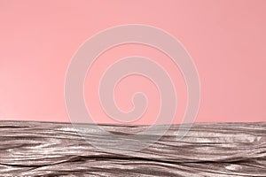 Shiny silver fabric on pink background. Free space, copy space for your text and design. Events, celebrations, Christmas