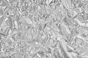 Shiny silver foil texture background, pattern of wrapping paper with crumpled and wavy