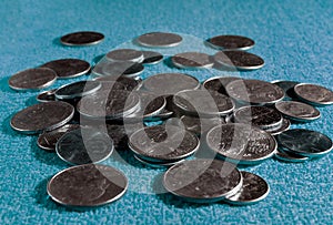 Shiny silver and golden usa coins on light blue fabric textured background