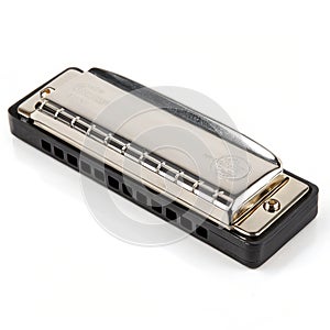Silver harmonica on black isolated on white background
