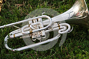 Shiny silver marching baritone instrument resting on the field d