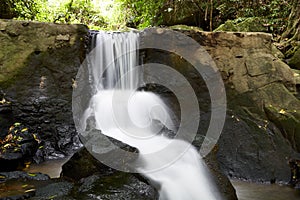 Shiny slow flowing white waterfall cascade