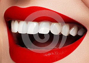 Shiny smile with whitening teeth and bright red lips. Dental photo. Macro of fashion makeup