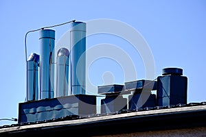 shiny stainless steel sheet mechanical air pipes, vents and ducts on flat roof. building engineering concept
