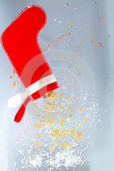 Shiny stars with snow are falling from a Santa Claus Christmas sock.