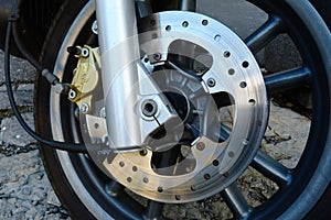 Shiny steel front brake disc detail on scooter or motorcycle