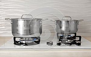 Shiny steel saucepans on gas stove
