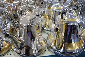 Shiny tea pots Arabian style coffee pods Gold and Silver