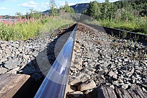 The shiny top view of a rail on a train track