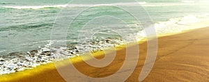 Shiny tropic sea wave on golden beach sand