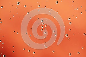 Shiny water drops on orange red background