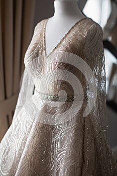 Shiny wedding dress hanging on a mannequin
